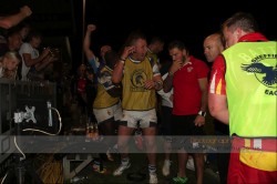 Players from both teams crowd round a television